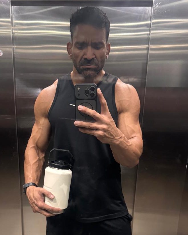 Emanuel Matos de regata preta, segurando a garrafa de água, depois do treino